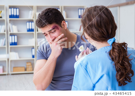 Young man visiting female traumatologist with black eye Young man visiting female traumatologist with black eye 43465415