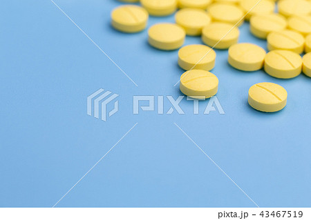 yellow pills on blue background 43467519