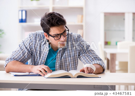Young student man with hand injury preparing for the exams  43467581