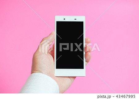 スマートフォンを使う手　ピンク色背景 43467995