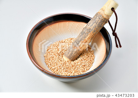 すり鉢と白ごま。小さいサイズのすり鉢と擂粉木、白ごま（炒りごま）です。ゴマはまだ擦っていません。 43473203