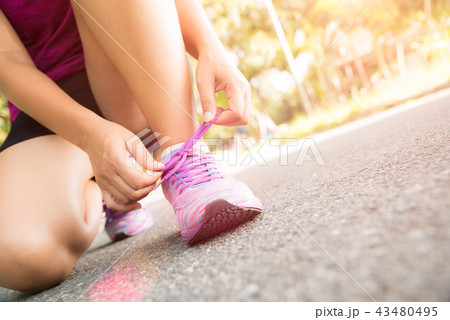 Running shoes - closeup of woman tying shoe laces Running shoes - closeup of woman tying shoe laces 43480495