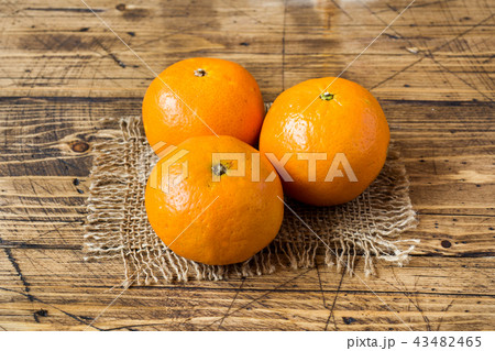 Three tangerines on a napkin on a wooden rustic Three tangerines on a napkin on a wooden rustic 43482465