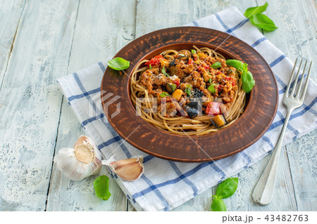 Pasta with bolognese sauce, vegetables and basil. 43482763