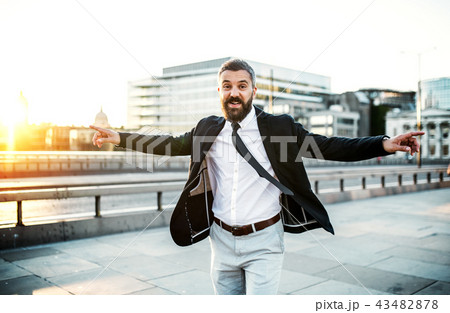 Cheerful hipster businessman walking on the bridge in the city, arms stretched. Cheerful hipster businessman walking on the bridge in the city, arms stretched. 43482878