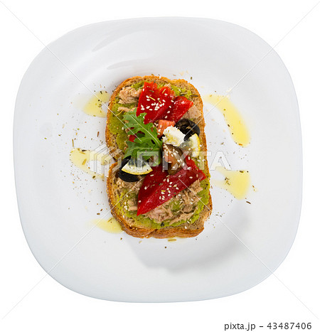 Top view of sandwich with guacamole, canned tuna, feta, vegetables on white plate 43487406