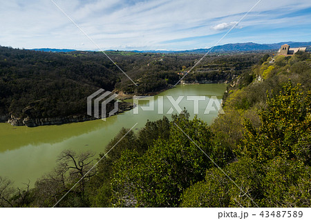 Monestir de Sant Pere de Casserres located among the mountains and river 43487589