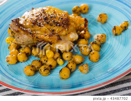 Dish of tasty fried chicken thighs served with cheakpea at plate Dish of tasty fried chicken thighs served with cheakpea at plate 43487702