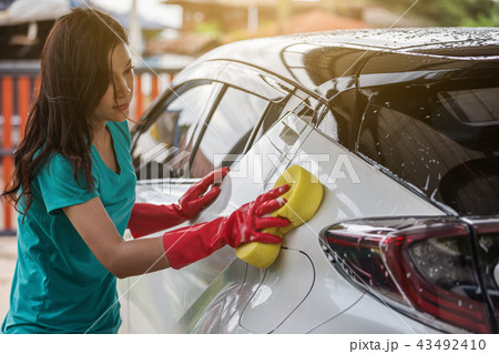 woman holding sponge to washing car woman holding sponge to washing car 43492410