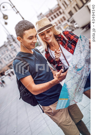 Smiling couple looking for direction traveling in city 43494540