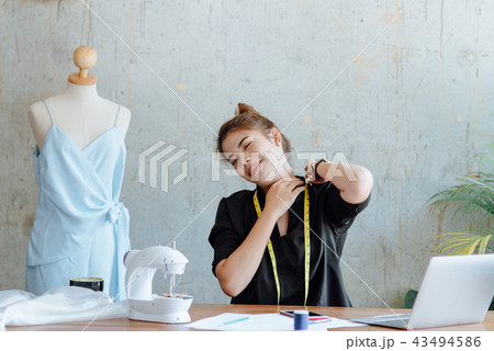 Young designer stretching herself while work Young designer stretching herself while work 43494586