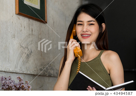 Beautiful Asian woman talkig with vintage phone Beautiful Asian woman talkig with vintage phone 43494587