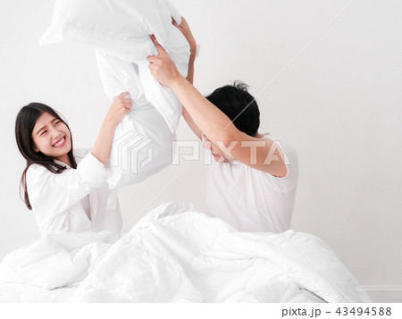 Happy Asian couple playing pillow on bed, Happy Asian couple playing pillow on bed, 43494588