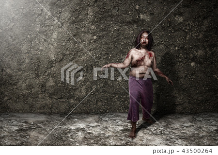 Scary zombie man standing against grunge background Scary zombie man standing against grunge background 43500264