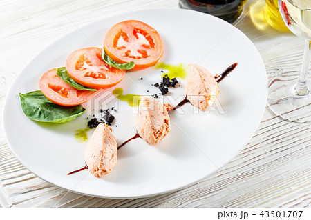 Caprese salad with mozzarella, tomato, basil and balsamic vinegar arranged on white plate 43501707