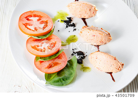 Caprese salad with mozzarella, tomato, basil and balsamic vinegar arranged on white plate 43501709