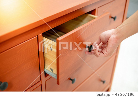 Male hand opening drawer on wooden cabinet 43507196