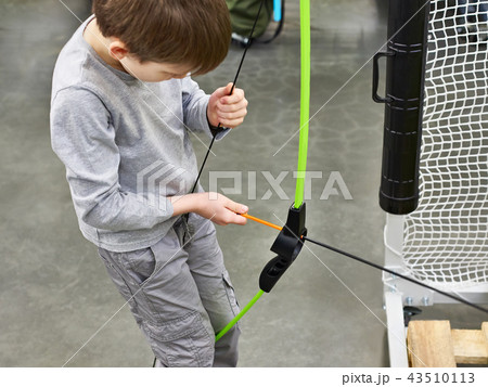 Little boy sets arrow in children's sports bow Little boy sets arrow in children's sports bow 43510113