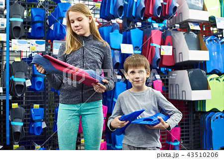 Children choose swim fins in sports shop 43510206