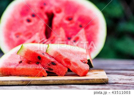Slices and half of fresh watermelon on wooden board 43511003