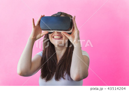 Woman using VR headset on pink background Woman using VR headset on pink background 43514204