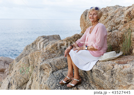 Senior woman relaxing at seaside Senior woman relaxing at seaside 43527445