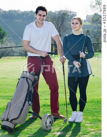 Male and female golfers ready for team play at golf course Male and female golfers ready for team play at golf course 43527989