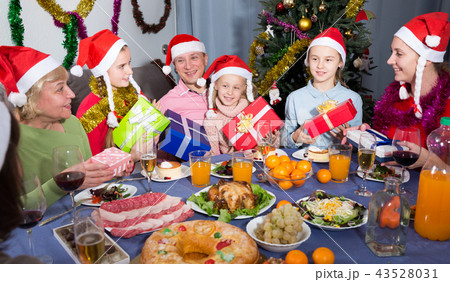 Portrait of happy family who is sitting with gifts in time celebrating New Year Portrait of happy family who is sitting with gifts in time celebrating New Year 43528031