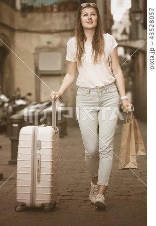 young tourist taking walk in city with the travel bag 43528057
