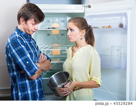 Unhappy hungry couple near empty fridge 43529284