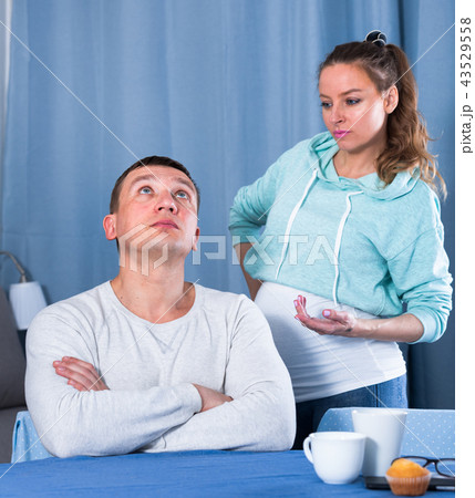 Husband and pregnant wife arguing at home 43529558
