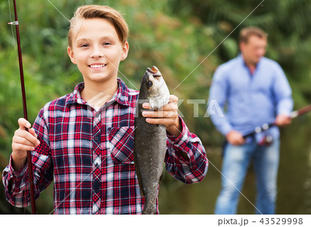 Fisher boy showing catch fish 43529998