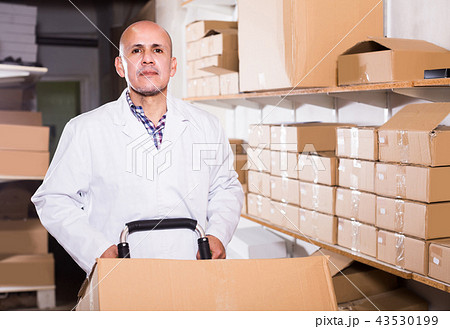 Portrait of mature male with carton boxes in warehouse 43530199