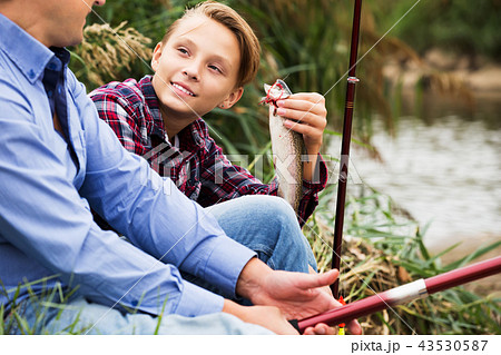 Fisher boy showing catch fish 43530587