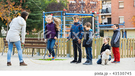 Children playing rubber band jumping game and laughing Children playing rubber band jumping game and laughing 43530745
