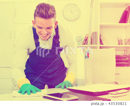 Male professional janitor dusting in office 43530821