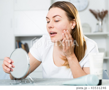 Young woman is satisfied of quality her skin in with mirror Young woman is satisfied of quality her skin in with mirror 43531246