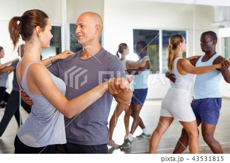 Young positive people dancing together slow ballroom dances in pairs Young positive people dancing together slow ballroom dances in pairs 43531815