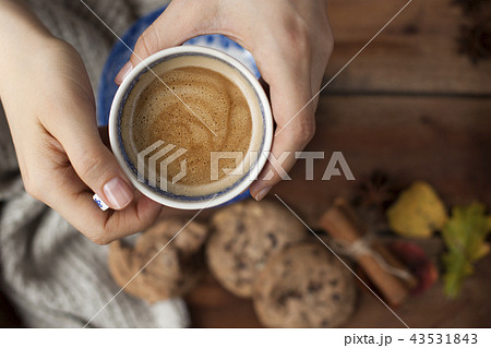 Morning fragrant coffee in a female hand and a wooden background. Biscuit biscuits with chocolate 43531843