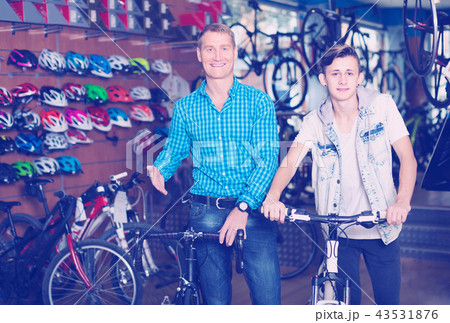 father with son choosing bike in store. father with son choosing bike in store. 43531876