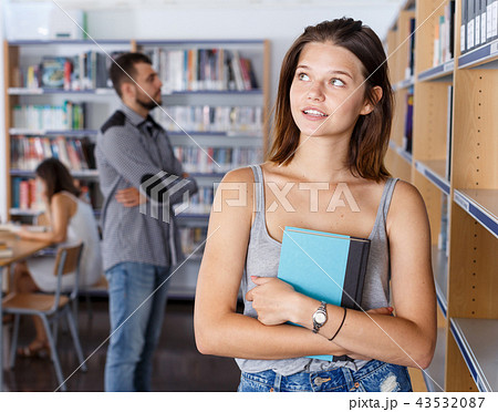 Young woman with book in library 43532087