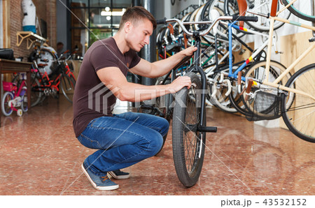 Male is shopping and choosing new bicycle 43532152