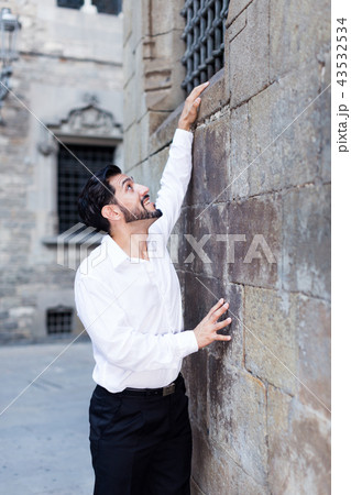 Man trying to climb stone wall Man trying to climb stone wall 43532534