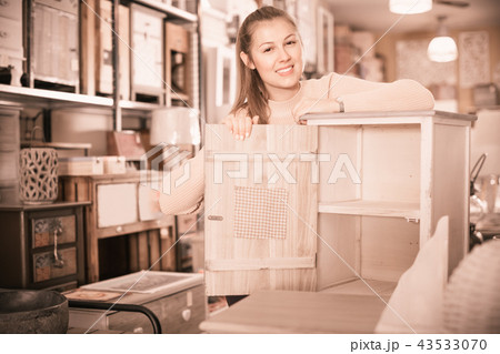 Female choosing bedside table in the furniture store 43533070
