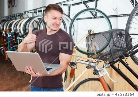 Man is looking in laptop and choosing modern bicycle 43533264