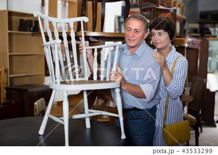 Female with her husband are buying antique armchair Female with her husband are buying antique armchair 43533299