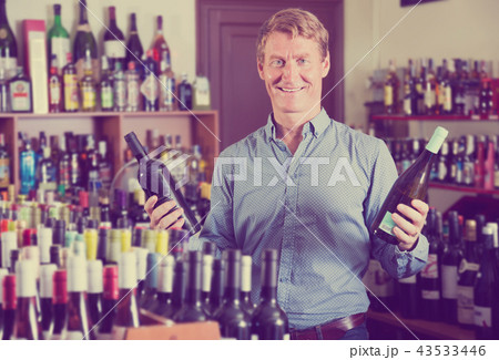 happy man customer buying bottle of wine 43533446