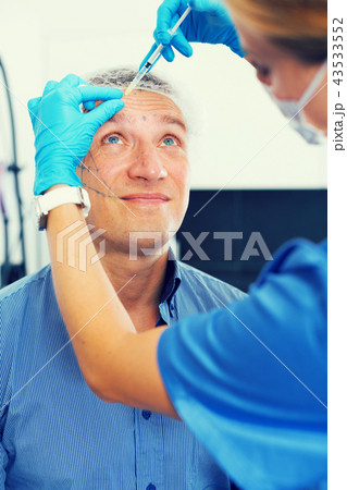 Female doctor is doing injection to patient in skin of face Female doctor is doing injection to patient in skin of face 43533552