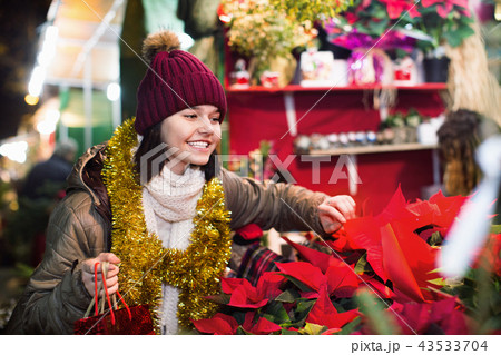 Girl buying floral compositions at Christmas market 43533704