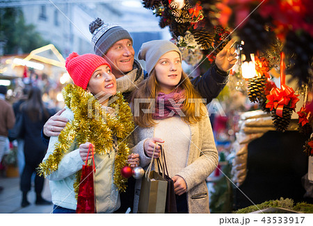 Family couple with teen girl choosing decoration Family couple with teen girl choosing decoration 43533917
